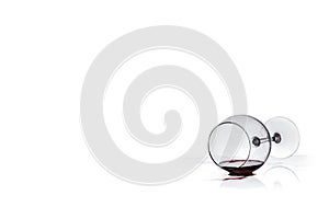 Wine glass with red wine lies on glass on white background