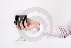 Wine glass with red wine in woman hands isolated on white background