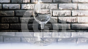 Empty glass of wine on a brick wall background,close-up