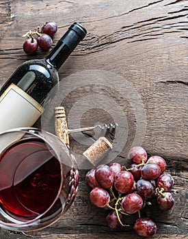 Wine glass, wine bottle and grapes on wooden background. Wine ta