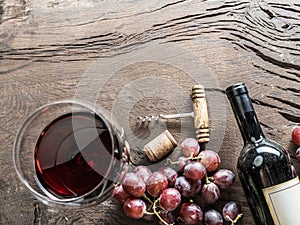 Wine glass, wine bottle and grapes on wooden background. Wine ta