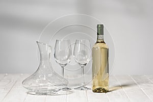 Wine glasses, bottle of wine and jug on wooden surface in restaurant