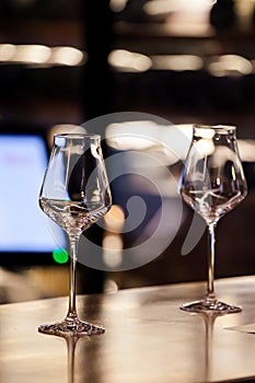 Wine glasses and bottles of wine in the entourage of the wine bar in the evening