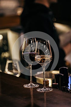 Wine glasses and bottles of wine in the entourage of the wine bar in the evening