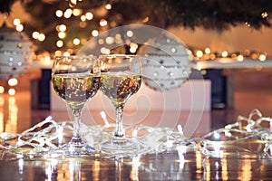 Wine glasses with bubbly drink for celebration toast wrapped in a Christmas light