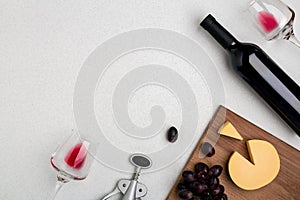 Wine, glasses and corkscrew over white background. Top view