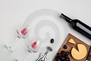 Wine, glasses and corkscrew over white background. Top view