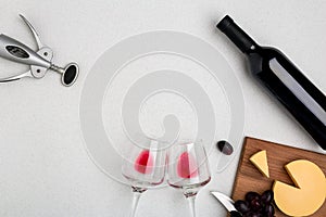 Wine, glasses and corkscrew over white background. Top view