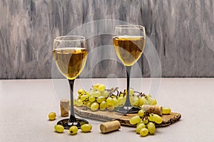 Wine glasses, fresh grapes and corks on wooden chopping board. Wine bar, winery, wine tasting concept photo