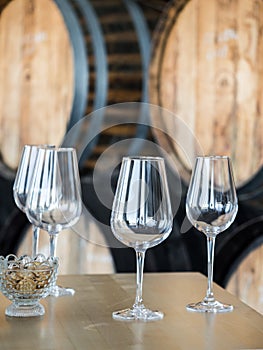 Wine glasses in front of wooden wine barrels photo