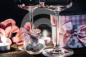 Wine glasses, gift and candles for romantic evening