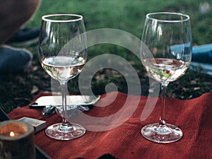 Wine glasses and hamper picnic scene outdoor.