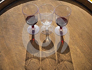 Wine glasses with wine on the end of a wooden barrel