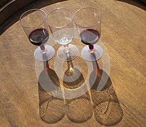 Wine glasses with wine on the end of a wooden barrel