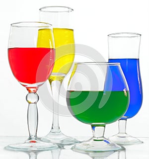 Wine glasses with yellow, blue, green and red liquid