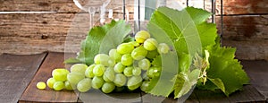 Wine grapes on wooden background with wine cork.