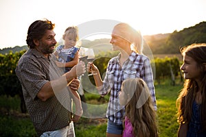 Wine grower family in vineyard talking and smiling