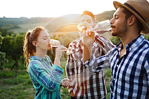 Wine growers tasting wine in vineyard