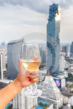 Wine in the hand hold asian women and dine in the bangkok city background