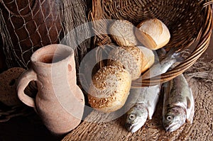 Wine jug with bread and fish photo