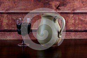 Wine Jug and Glass of Red Wine on a Polished Wooden Shelf