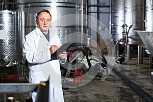 Wine maker examines equipment at winery