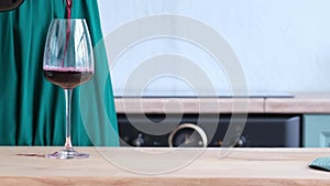 wine is poured into a glass goblet standing on the table