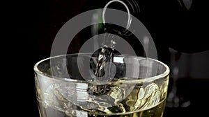 Wine is pouring into the glass from the bottle the camera is moving slow mo