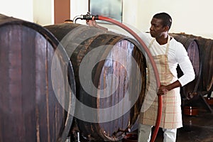 Wine producer controlling production wine in winery, preparing for wine filtration