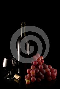 Wine and red grape on black