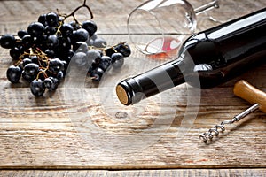 Wine set with bottle and grape on wooden desk
