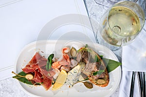 Wine set. jamon, prosciutto, parmesan sausage, veal balyk and glass of white wine. Place for text