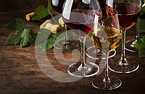 Wine set. Red, white and rose wine in assortment in wineglasses. Wine tasting, vintage wooden background, selective focus, copy