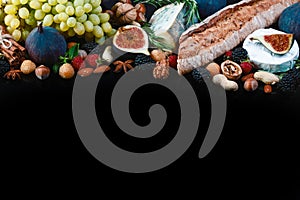 Wine and snack set. Baguette, white, figs, grapes, nuts, cheese variety, meat appetizers and herbs Frame isolated on black