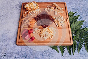 Wine and snack set. Variety of cheese, olives, prosciutto, roasted baguette slices, grapes on wooden board and glasses