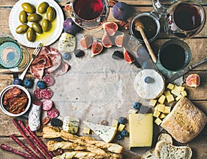 Wine and snack set with wines, meat, bread, olives, fruits
