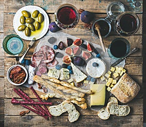 Wine and snack set with wines, meat, bread, olives, fruits