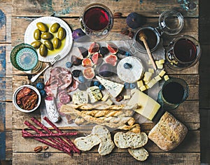 Wine and snack set with wines, meat, bread, olives, fruits