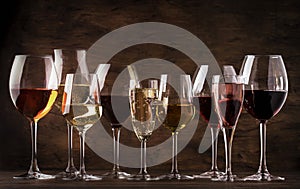 Wine tasting concept, still and sparkling wines. Red, white wine, rose and champagne in wine glasses on vintage wooden table photo