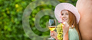 Wine tasting in outdoor winery. Grape and wine making. Woman tasting wine in vineyard. She is showing glass of wine