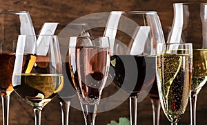 Wine tasting. Red, white, rose and champagne - still and sparkling wines sin glasses on vintage wooden table background