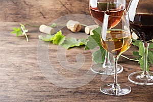 Wine tasting. Red, white, rose- still wines sin glasses on vintage wooden table background photo