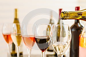 Wine tasting set in the light airy environment. Pouring into the glasses. Custom wine tasting concept