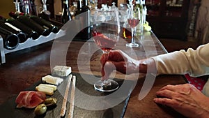 Wine test, crystal glass, red wine, cheese, bar counter background. Glasses of wine and cheese plate. Wine testing.