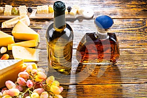 Wine and Whiskey on Table with Cheese and Grapes