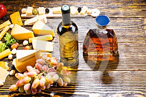 Wine and Whiskey on Table with Cheese and Grapes