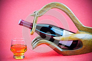 Wine with wooden support on red background. Drinking on celebrate day