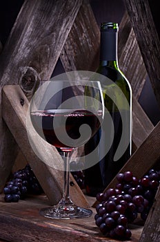 Wineglass and bottle in a rustic wine cellar setting.