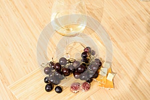 Wineglass with grape, cheese and meat