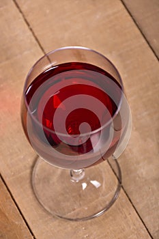 Wineglass with the red wine on the wooden table